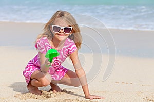 Happy little girl playing on the beach