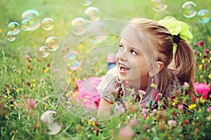 Happy little girl playing with bubbles