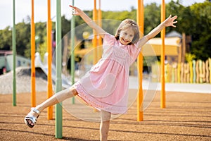 Happy little girl playing on a children& x27;s playground