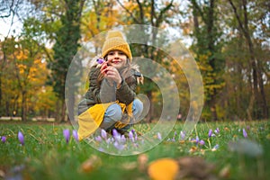 Happy little girl playing outdoor in autumnal park