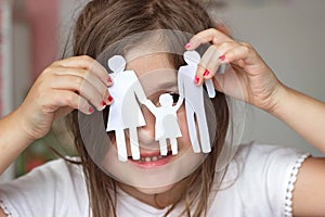 Happy little girl playing with paper chain family; happy family