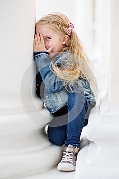 Happy little girl playing peekaboo