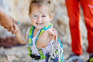 Happy little girl playing with rock climbing equipment