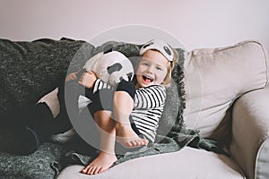 Happy little girl playing with soft big plush panda at home. Concept of family, healthy sleep of child, upbringing, parenting. Ð¡