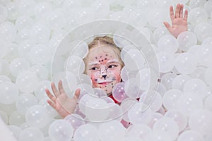 Happy little girl in a playroom in a white room