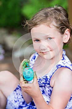 Happy Little Girl Poses with Painted Easter Egg