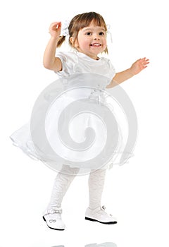 Happy little girl posing in white dress