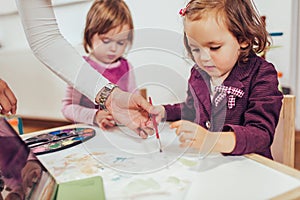 Happy little girl, preschooler, painting with water color