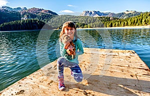 Happy little girl with a puppy by the Black Lake ( Crno jezero),Durmitor, Montenegro