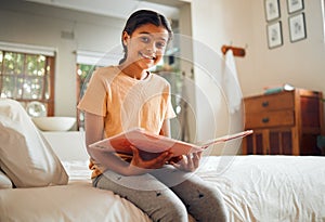 Happy little girl, reading book and bed with smile for story time, education or learning in comfort at home. Portrait of