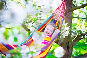 Happy little girl relaxing in a hammock