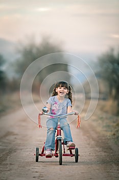 Happy Little Girl Riding Her Tricycle