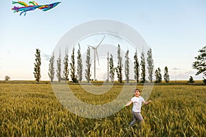 Happy little girl running around with a kite on the Wheat field