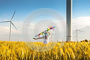 Happy Little girl running in a wheat field with a kite in the summer.