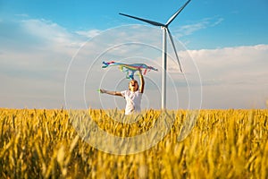 Happy Little girl running in a wheat field with a kite in the summer.