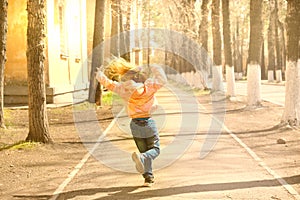 Happy little girl runs with her hands up outdoors. Freedom and carefree. Happy childhood