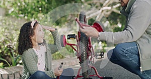 Happy little girl saying good bye to training wheels on her bicycle with grandpa. Proud, caring grandparent helping his