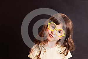 Happy little girl schoolgirl from the blackboard