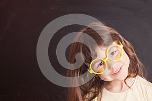 Happy little girl schoolgirl from the blackboard