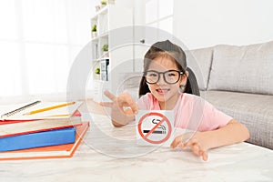 Happy little girl showing quit smoking symbol sign