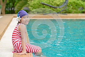 Happy little girl sit in outdoor swimming pool