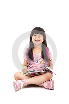 Happy little girl sitting and reading a book