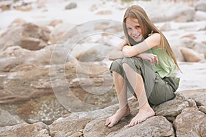 Happy Little Girl Sitting On Rock