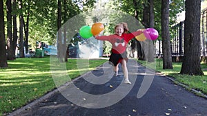 Happy little girl in skirt runs and jumps with balloons