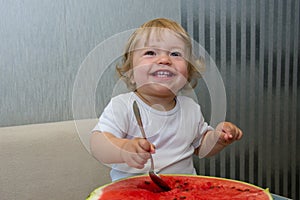 One-year-old girl eats the pulp of watermelon spoon, the first independent use of vitamins, sweet berries