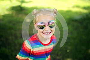 Happy Little Girl Smiling Outside Wearing Heart Shaped Sunglasses