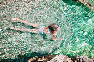 Happy little girl in snorkeling mask dive underwater with tropical fishes