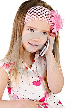 Happy little girl speaking by cell phone isolated