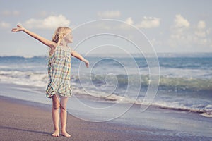 Happy Little girl standing on the beach