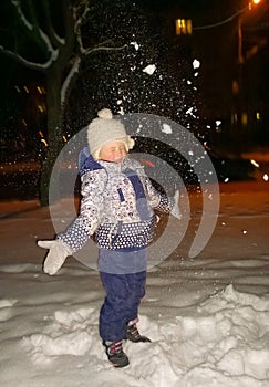 happy little girl standing on city street in winter evening.