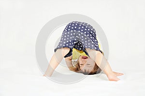 Happy little girl standing on head upside down