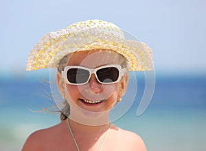 Happy little girl in sunglasses on beach