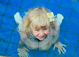 Happy little girl in a swimming pool