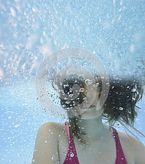 Happy little girl swimming in a pool