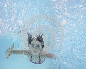 A happy little girl swimming in a pool