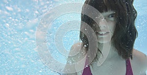 A happy little girl swimming in a pool