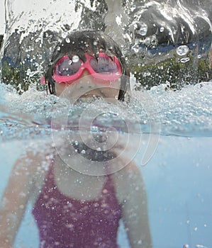 A happy little girl swimming in a pool