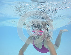 A happy little girl swimming in a pool