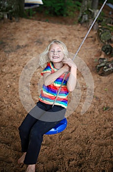 Happy Little Girl Swinging and Playing Outsie at Beach