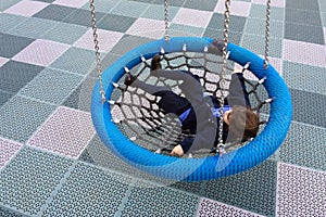 Happy little girl swings on Birds Nest Swing