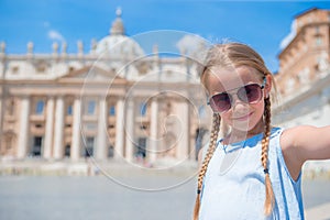 Happy little girl taking selfie background St. Peter`s Basilica church in Vatican city.