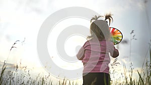 Happy little girl with a toy in the park. A child with a colored toy in the park. Happy little girl is playing in the