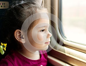 Happy little girl traveling by train.