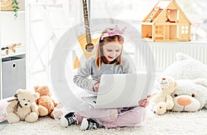 Happy little girl using computer