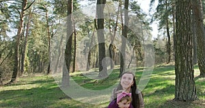 Happy little girl walking and playing with mother among trees in coniferous forest. Healthy child family recreation in