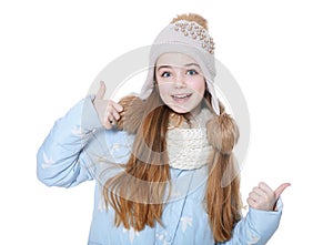 Happy little girl in warm clothes showing thumb up